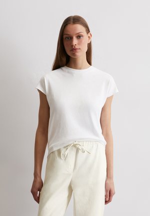 Witte katoenen t-shirt met korte mouwen, ronde halslijn en een ontspannen pasvorm, gecombineerd met lichtbeige joggingbroek met trekkoord.