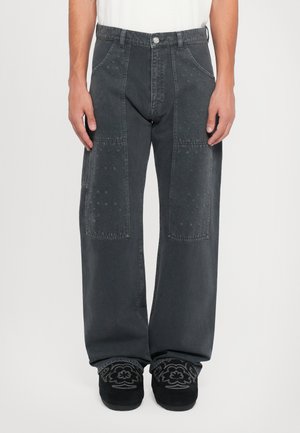 Brede, donkergrijze jeans met een knoopsluiting, voorzien van getextureerde patchwork op de voorkant en subtiele borduurdetails op de benen.