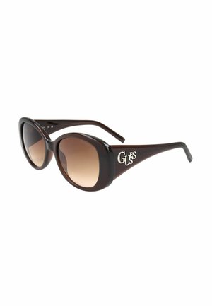 Occhiali da sole oversize marrone scuro con lenti marroni sfumate e logo argentato "GUESS" sulle aste, mostrati su sfondo bianco.