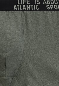 Szare bawełniane szorty mają czarną elastyczną talię z napisem "ŻYCIE JEST O ATLANTYCKICH SPORTACH". Posiadają boczne kieszenie i miękką fakturę.