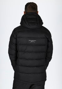Svart puffjacka med huva, tillverkad av vadderat material. Har en logotyp på den övre ryggen och en elegant, strömlinjeformad design.