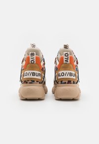 Sneaker colorate con un design in materiali misti, caratterizzate da una base beige, una parte superiore con stampa leopardata e accenti di branding prominenti sul tallone.