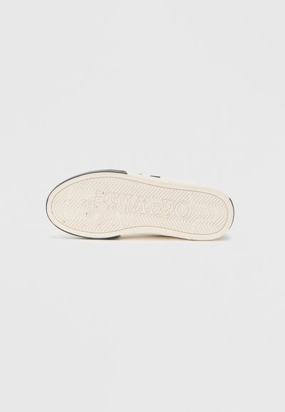 Sole de sneaker alb cu un design din cauciuc texturat și un model de striație, având un accent negru și un logo la călcâi.
