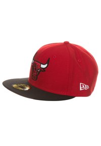 Gorra de béisbol roja con visera negra, que presenta un logo bordado de los Chicago Bulls en la parte frontal y un pequeño emblema de New Era en el costado.