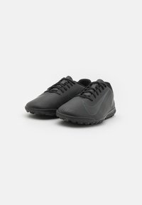 Zapatillas deportivas negras con parte superior texturizada, diseño estriado y un delgado acento azul. Presentan un cierre con cordones y suela de goma para mayor tracción.