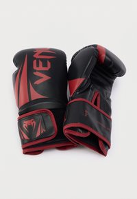 Μαύρα και κόκκινα πυγμαχικά γάντια από συνθετικό δέρμα, με κομψό σχεδιασμό, ενισχυμένα ραφές και κλείσιμο καρπού με βέλκρο. Μέγεθος 10 ουγγιές.