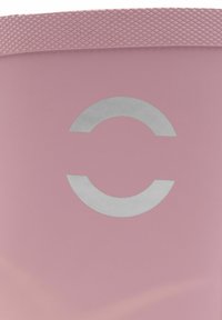 Vaaleanpunainen tuote, jolla on sileä pinta ja keskellä erottuva hopeinen pyöreä logo. Yläreunassa on teksturoitu kaistale.