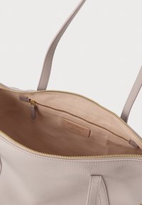 Τσάντα ώμου από δέρμα σε ανοιχτό ροζ χρώμα με χρυστό φερμουάρ, λεία υφή και ευρύχωρο εσωτερικό. Διαθέτει ετικέτα με το όνομα της μάρκας στο εσωτερικό.