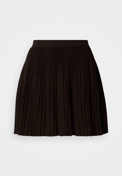 Jupe plissée noire avec une surface texturée, dotée d'une large ceinture élastique. Le design présente des plis verticaux pour un look structuré.