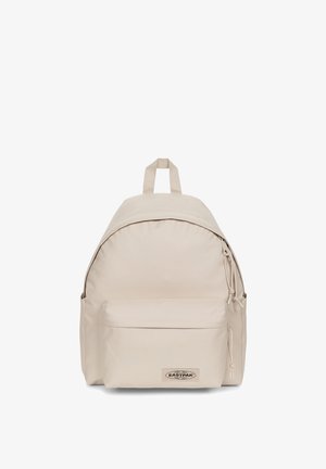 Zaino Eastpak beige con forma arrotondata, materiale in tessuto, tasca frontale con cerniera, manico superiore e spallacci regolabili.
