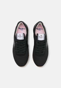 Pair of black Pepe Jeans London sneakers with fabric texture, black laces, white tongue label, and pink insoles on a white background.