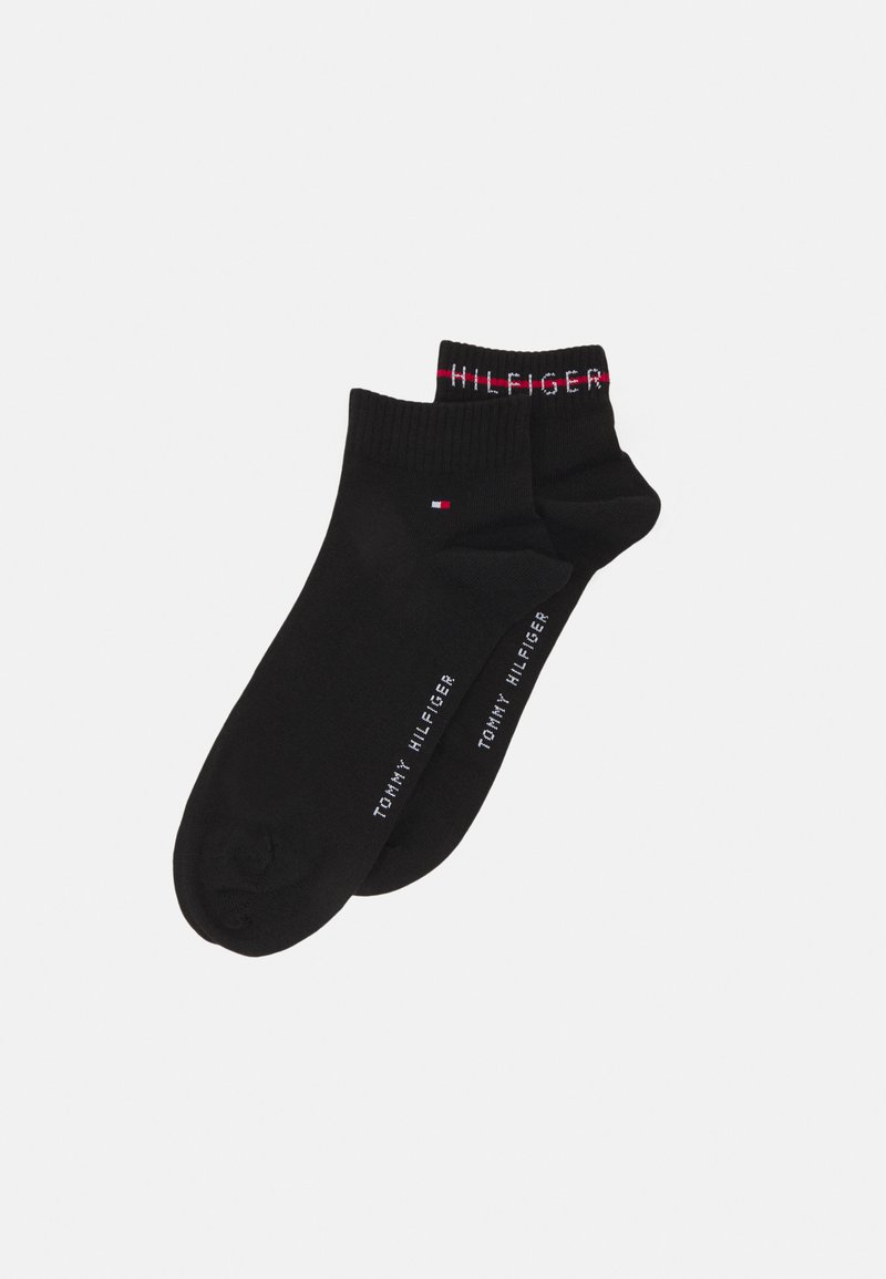 Zwarte katoenen ankelSokken met ribgebreide boorden, witte geborduurde "TOMMY HILFIGER" branding en een klein rood en wit logo.