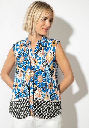Short-sleeve blouse in vibrant floral and geometric patterns. Features blue, orange, and black on a white background. Lightweight fabric.