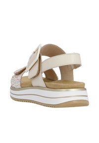 Sandalo beige con upper in tessuto intrecciato, cinturino regolabile con una grande fibbia e soletta imbottita su una suola in bianco e beige.