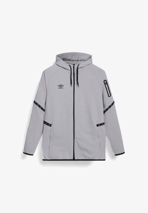 Chaqueta con capucha de cremallera completa en gris claro, con ribetes negros, logo de la marca en negro, bolsillo con cremallera en la manga y franjas decorativas negras en las mangas y los bolsillos.