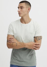 Lys grønn og mørk grønn gradient kortermet T-skjorte med brystlomme, laget av mykt stoff, med rund hals.