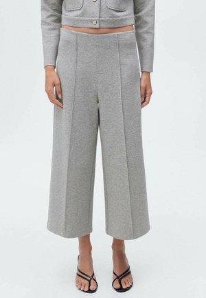 Pantalones de pierna ancha gris confeccionados en tejido suave, con pliegues frontales cosidos, una cintura de altura media y un ajuste relajado.