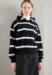 Felpa con cappuccio a righe navy con strisce orizzontali bianche, dotata di un logo sul petto, cappuccio con cordino e tessuto morbido e testurizzato.