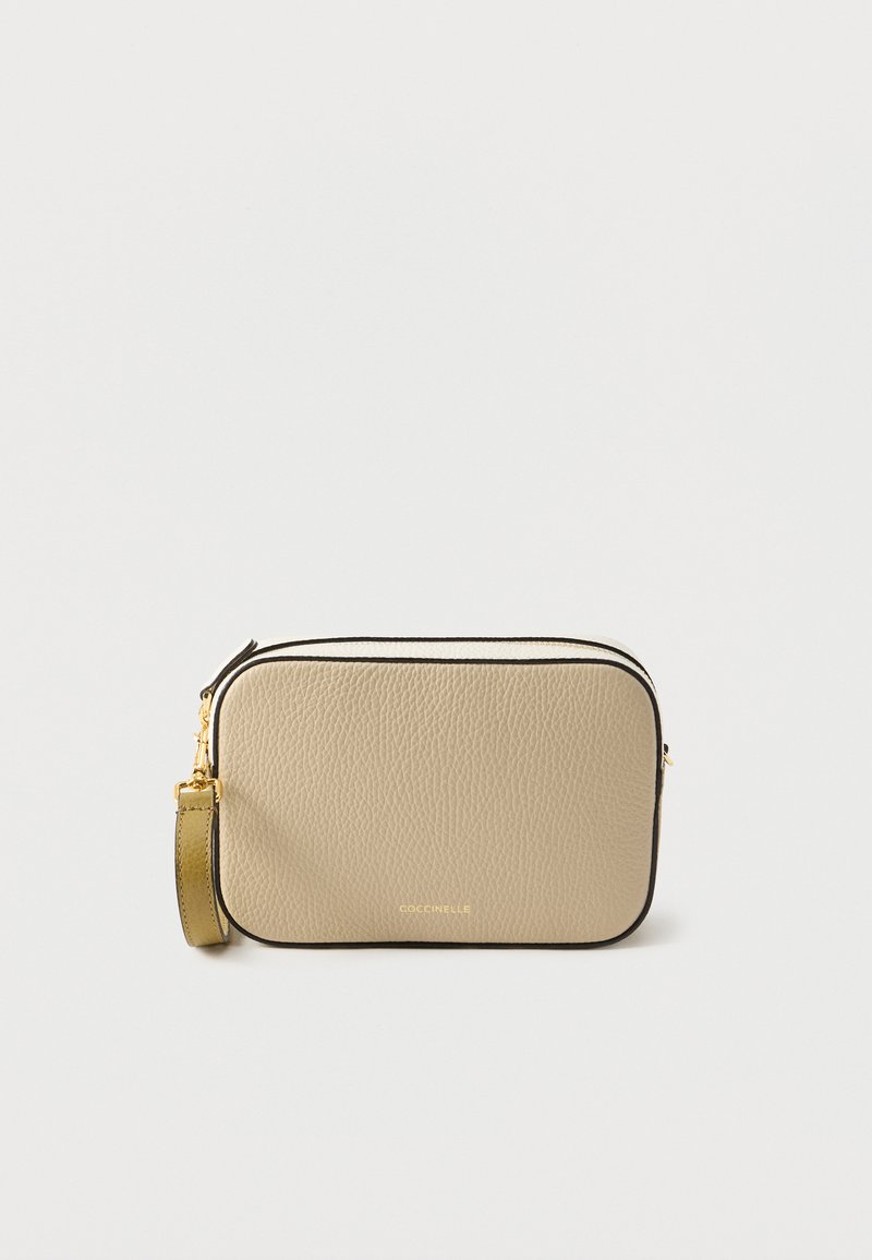 Beige leather crossbody bag with a textured finish, black piping, gold hardware, and a detachable strap for versatile carrying options.