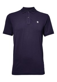 Polo bleu marine à manches courtes avec deux boutons et petit logo blanc sur la poitrine gauche.