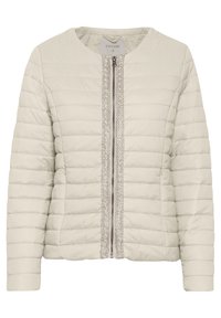 Jasnobeżowa pikowana kurtka z okrągłym dekoltem, zapięciem na zamek błyskawiczny z przodu oraz ozdobnym srebrnym wykończeniem wzdłuż linii zamka.