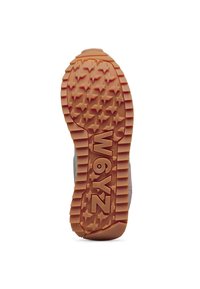 Rubber shoe outsole in orange with star-patterned tread and prominent branding. Durable, textured surface for grip and traction.
