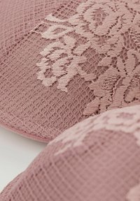 Spitzen-BH in sanftem Pink mit komplexen floralen Mustern, strukturiertem Stoff und glatten Kanten in einem nahtlosen Design.