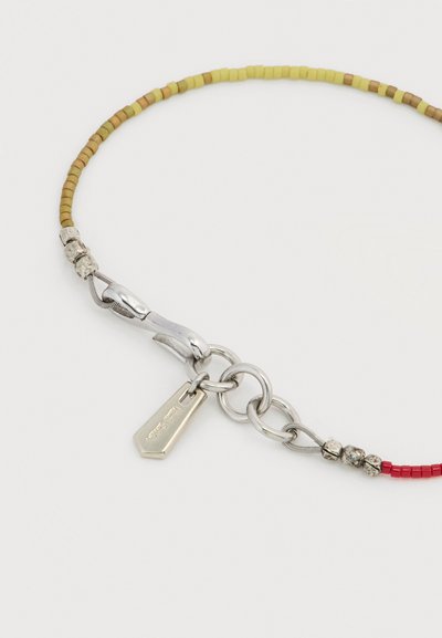 Βραχιόλι με χάντρες σε κόκκινο, κίτρινο και καφέ χρώμα, ασημένιο κούμπωμα, αλυσίδα με κρίκους και ένα ορθογώνιο ασημένιο ταμπελάκι προσαρτημένο.