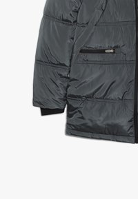 Kurtka puchowa w ciemnoszarym kolorze, z zamkiem błyskawicznym z przodu, poziomym pikowaniem oraz kieszenią na zamek po lewej stronie.