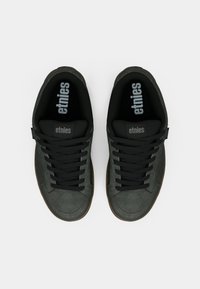 Μαύρα σουέτ αθλητικά παπούτσια με μαύρες κορδόνες, διαθέτοντας καουτσούκ σόλα και λογότυπο "etnies" στη γλώσσα και τη σόλα.