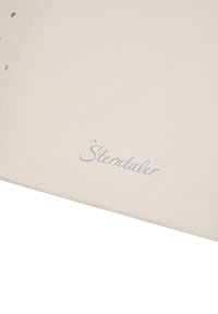 Cream-colored fabric with smooth texture. Features "Sterntaler" logo in soft blue and small decorative stars. Slightly curved edges.