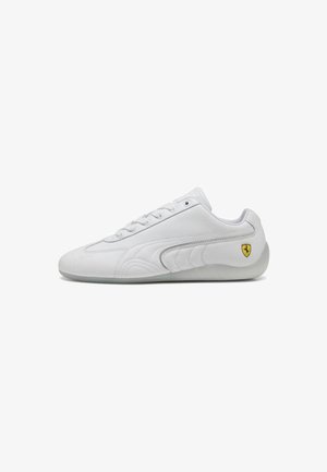 White athletic shoe with a smooth leather upper, lace-up design, and textured side panels. Features a small yellow Ferrari logo.