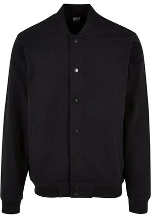 Chaqueta bomber negra confeccionada en tejido suave con un diseño sin cuello, cierre de botones a presión y dos bolsillos laterales. Presenta puños y dobladillo acanalados.