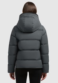 Chaqueta de plumas gris con una gran capucha, diseño acolchado y una textura suave. Terminada con un cuello negro y un detalle de cremallera lateral.