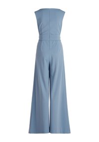 Világoskék, széles szárú overál, ujjatlan dizájnnal és hátsó cipzárral. Simára varrott anyag minimális varratokkal és deréknál formázott fazonnal.