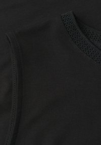 Haut en maille noir sans manches avec encolure ronde texturée et couture visible à l’épaule.