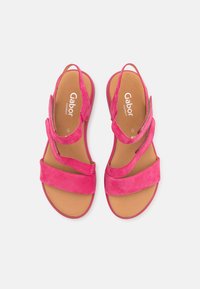 Pink suede sandals with multiple straps and a flat sole. Imprinted logo on the insole. Soft texture with a comfortable design.