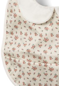 Blomsterforklæde med en kremfarvet baggrund, der har små pink og grønne blomster. Blødt, tekstureret materiale med en hvid scallopkrave.