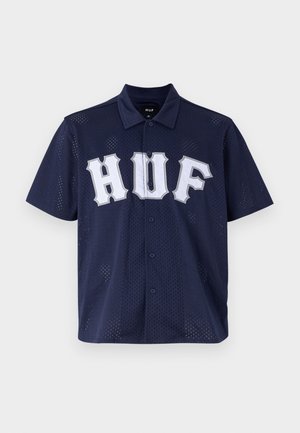 Short-sleeve navy mesh shirt with a buttoned collar, featuring a large white "HUF" logo on the front and subtle perforated texture throughout.