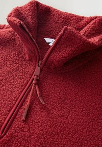 Rød fleece zip-up pullover med høj krave og en struktureret overflade. Har en lynlås med matchende pull tab og snore.