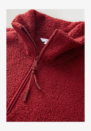 Sudadera de forro polar rojo con cremallera y cuello alto, de superficie texturizada. Cuenta con una cremallera con tirador a juego y cordones.