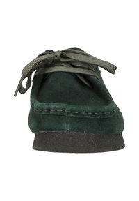 Tummanvihreä mokkanahkakenkä, jossa on pyöreä kärki ja kevyt musta pohja. Varusteena on samanväriset nauhat ja jykevä ompelu ylhäällä.