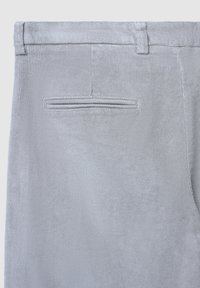 Pantaloni in velluto a coste grigi con taglio dritto, tessuto testurizzato e una tasca posteriore con apertura cucita in modo ordinato.