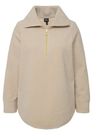 Sudadera de forro polar beige con cuello de media cremallera y detalle de cremallera dorada. Presenta mangas largas y dobladillo redondeado; textura suave.