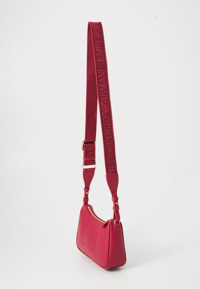 Red leather crossbody bag with gold zipper and adjustable wide fabric strap embossed with "Emporio Armani" text and logo.