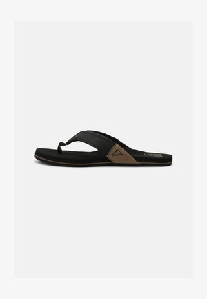 Sort flip-flop sandal med en tekstureret sort rem og en brun stofdetalje. Har en gummisål med en let grip-overflade.