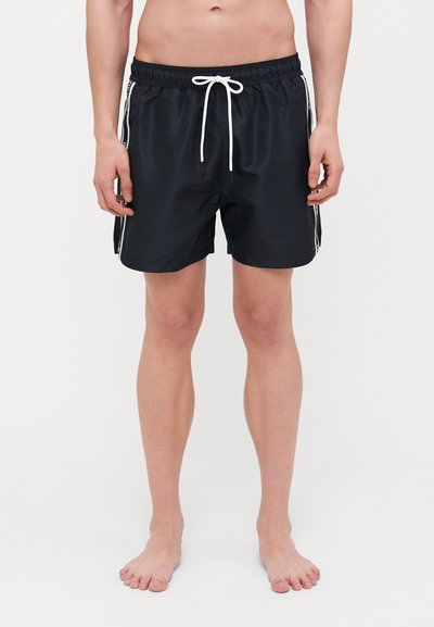 Schwarze Badeshorts mit einem elastischen Bund, weißen Kordeln und Seitentaschen, die an den Kanten kontrastierende weiße Streifen aufweisen.