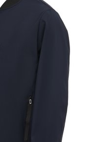 Námořnická modrá bunda vyrobená z hladkého materiálu, s kulatým výstřihem a boční kapsou na zip. Design zahrnuje bezšvové detaily na ramenech.