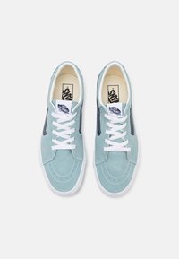 Hellblaue Wildledersneaker mit weißen Schnürsenkeln, runder Zehenpartie, kontrastierendem Seitenstreifen und Logo auf der Zunge. Flache Gummisohle.