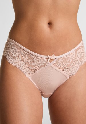 Zachtroze lingerie met kanten panelen en een zijden voorkant. Beschikt over een gekruist kanten ontwerp op de taille en een kleine strikaccent.
